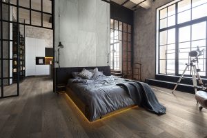 luxury studio apartment with a free layout in a loft style in dark colors. Stylish modern kitchen area with an island, cozy bedroom area with fireplace and personal gym